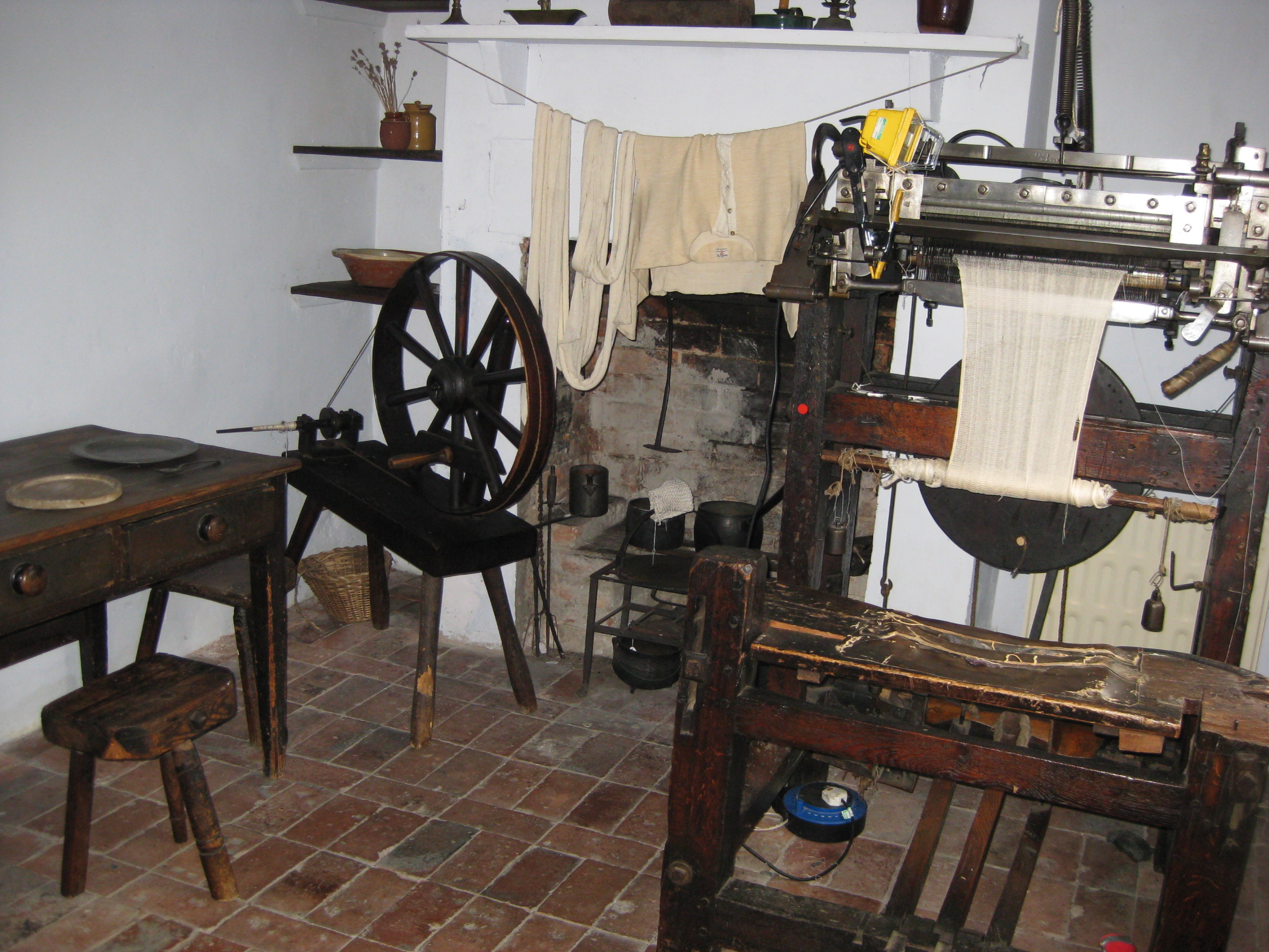 A knitting frame and spinning wheel in one of the cottages at the Framework Knitters Museum